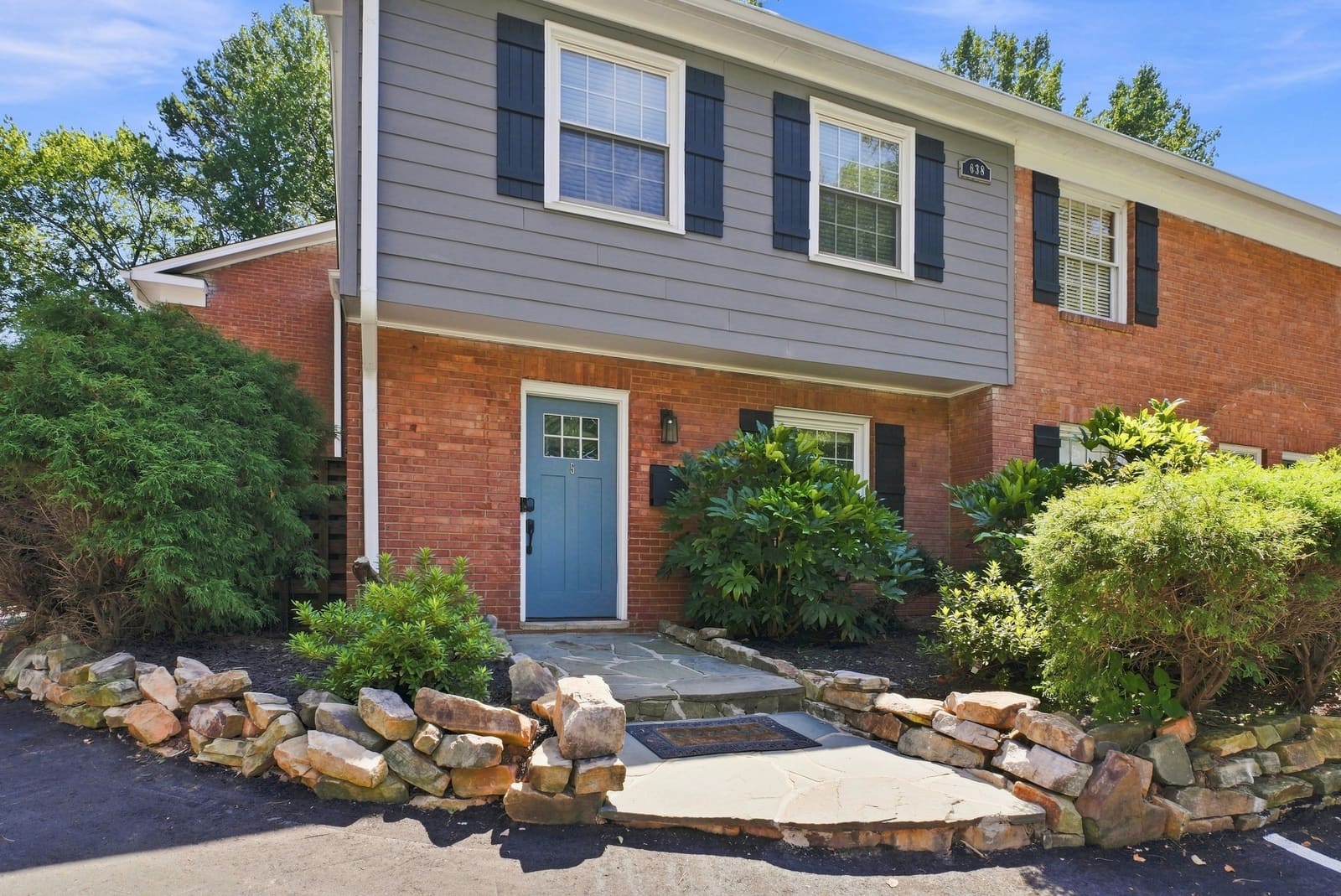 Casa Chipley's blue front door, brick exterior and planted entry
