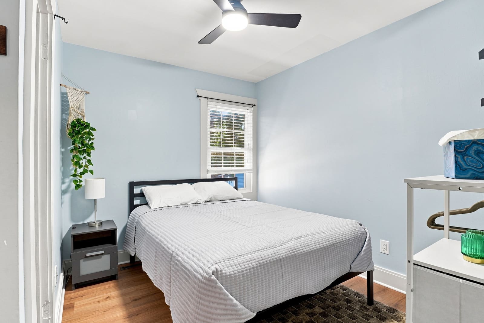 Queen bed in a pale blue bedroom
